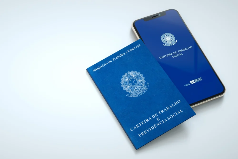 Carteira de Trabalho e Previdência Social com o brasão brasileiro ao lado de um celular com a Carteira de Trabalho Digital
