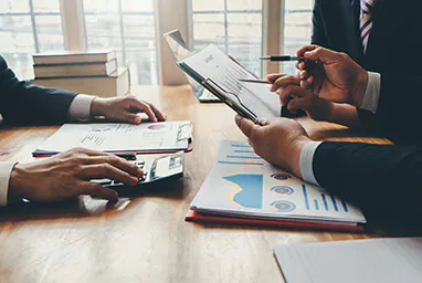 Profissionais reunidos para analisar documentos de uma empresa